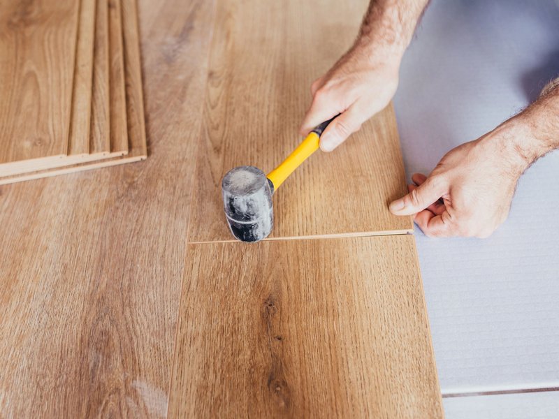 person installing flooring provided by Kenny's Custom Flooring Inc. in San Marcos, CA